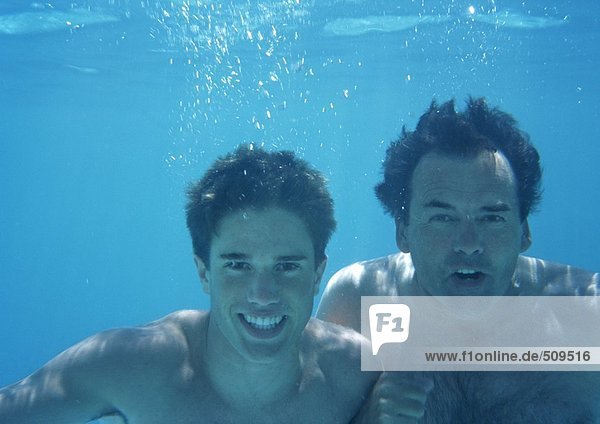 Man and teenage boy underwater.