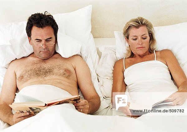 Couple lying in bed  reading