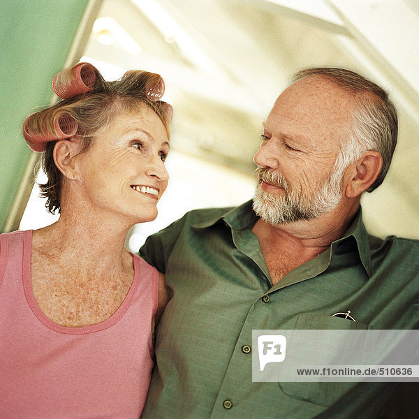 Mature couple looking at each other  woman with rollers in hair  portrait