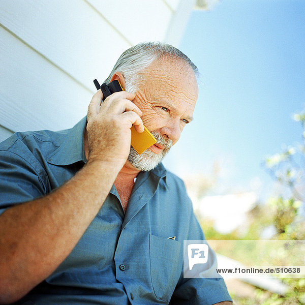 Mature man using cell phone  outside