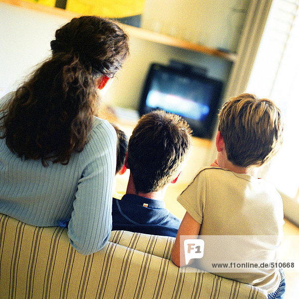 Familie auf dem Sofa sitzend fernsehen  Rückansicht