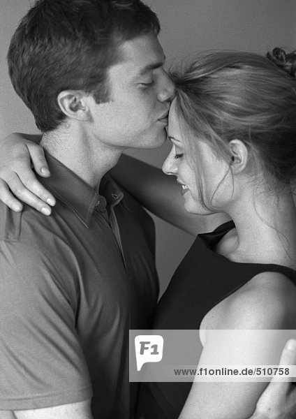 Paar umarmend  Mann küsst die Stirn der Frau  Seitenansicht  s/w