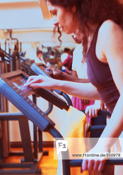 Frau mit Trainingsgeräten im Fitnessstudio  Seitenansicht
