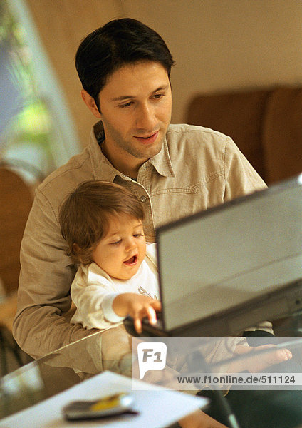 Vater und Baby mit Laptop.