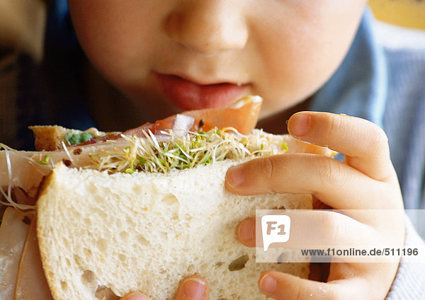 Kleines Kind isst Sandwich  Nahaufnahme.