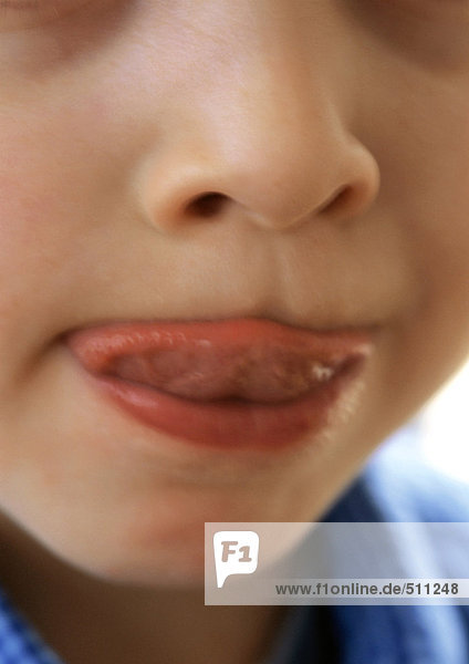 Kind leckt die Lippen  Nahaufnahme des Mundes.