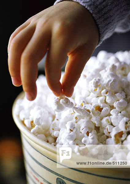 Kind isst Popcorn  Nahaufnahme von Hand und Popcorn