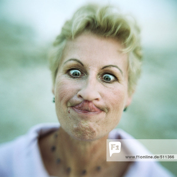 Porträt einer Frau mit gekreuzten Augen und zungenberührender Nase  Nahaufnahme