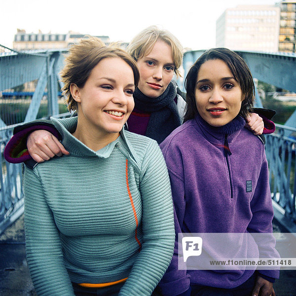 Drei junge Frauen auf der Brücke