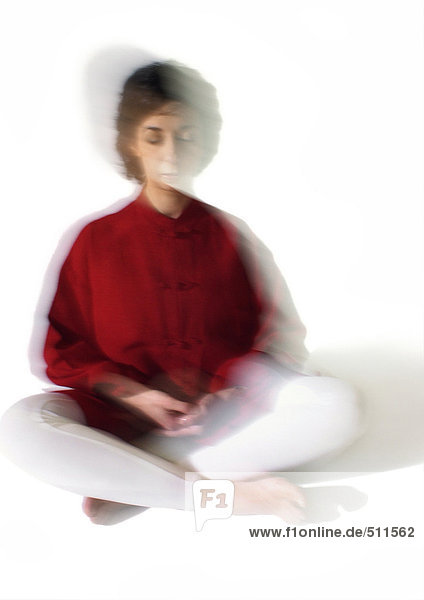 Frau sitzend im indischen Stil  meditierend  verschwommen