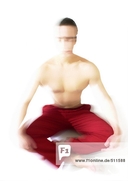 Oben-ohne-Mann auf dem Boden sitzend  meditierend