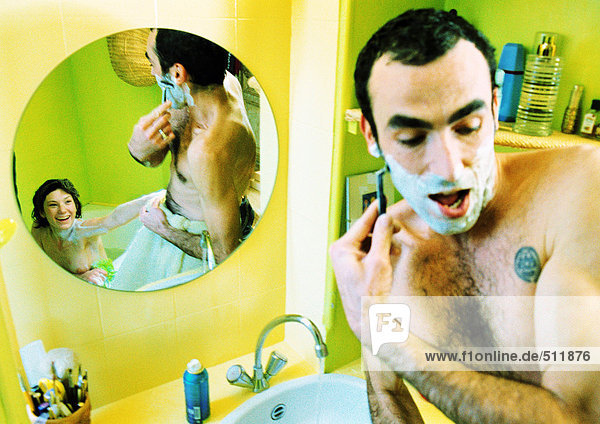 Mann beim Rasieren vor dem Spiegel  Frau im Spiegel sitzend in der Badewanne