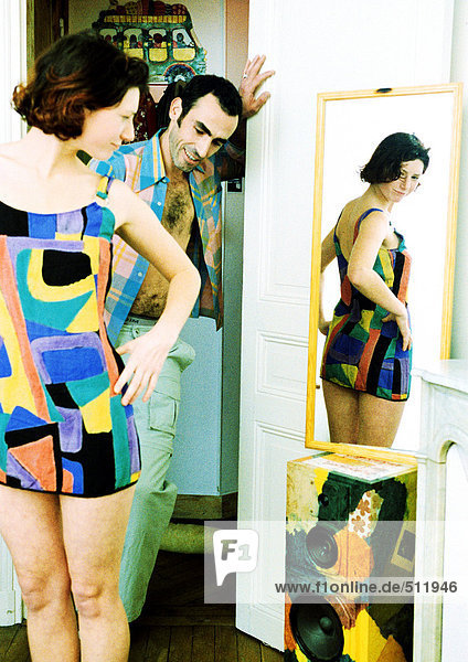 Ein Paar im Badezimmer  eine Frau  die sich im Spiegel betrachtet  ein Mann  der eine Frau betrachtet.