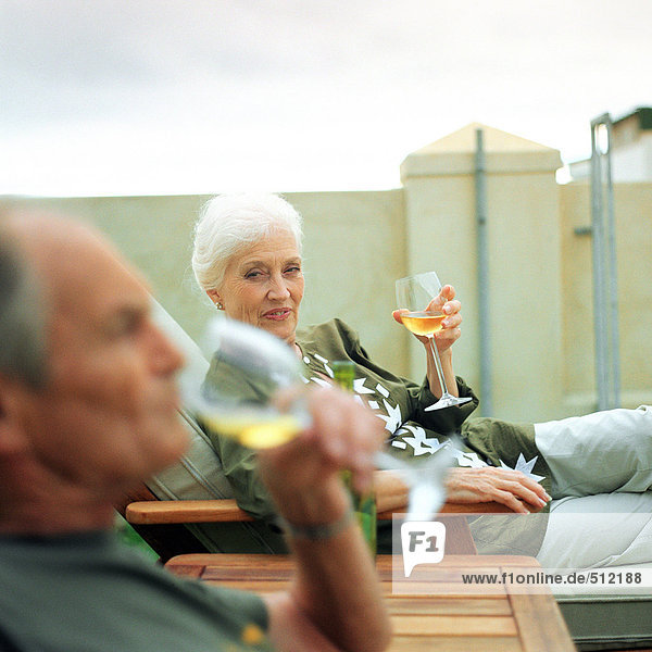 Erwachsener Mann und Frau bei einem Drink im Freien  Fokus auf Frau im Hintergrund