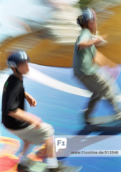 Zwei junge Männer auf Skateboards  verschwommen.
