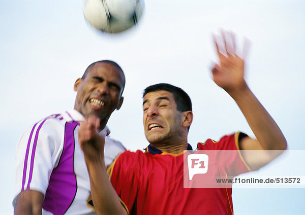 Zwei Spieler  die während eines Fußballspiels um den Ball kämpfen  verschwommen  Portrait.