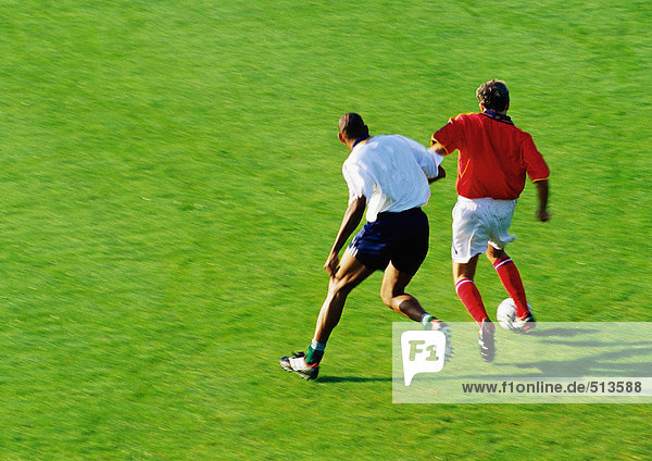 Zwei Fußballspieler laufen um den Ball  volle Länge