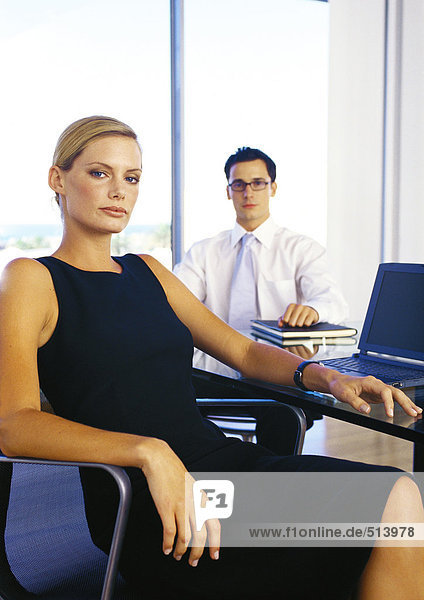 Businessman and woman sitting in office  portrait