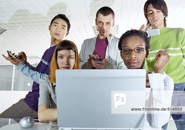 Group of young people gathered around computer