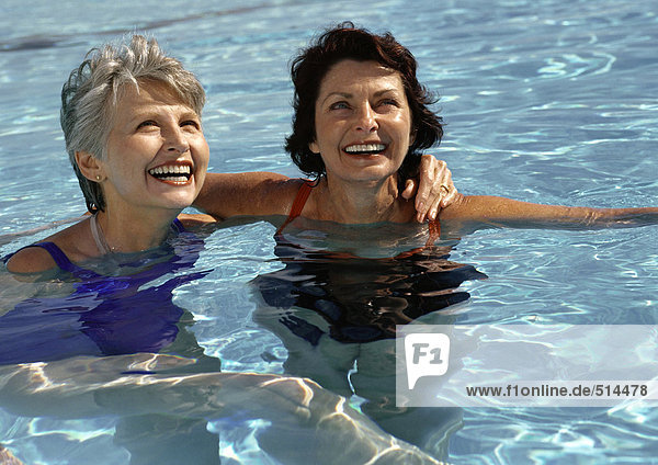 Two mature women in swimming pool  smiling