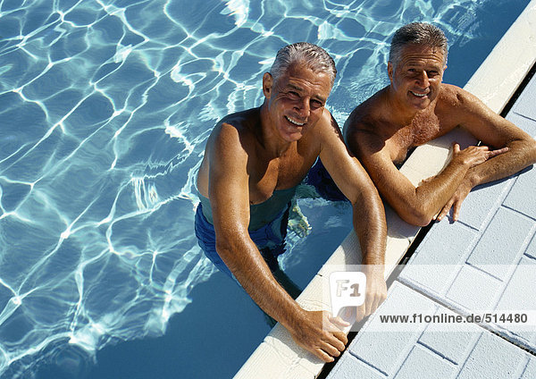 Two mature men resting on side of swimming pool  portrait  elevated view