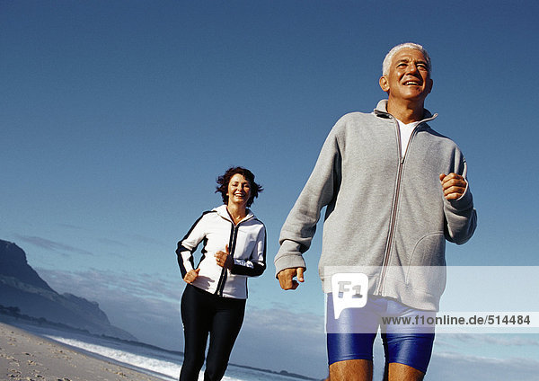 Mature couple running outdoors  low angle view