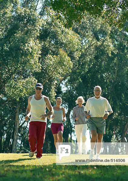Four mature joggers in park
