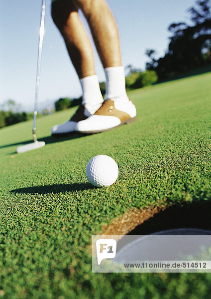 Golfer und Golfball in der Nähe des Lochs  niedriger Abschnitt