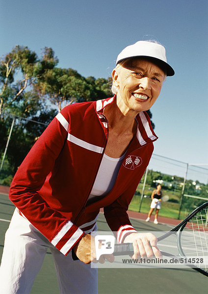 Mature woman holding tennis racket  portrait