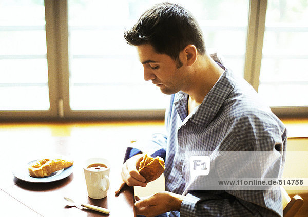 Mann im Pyjama beim Frühstücken