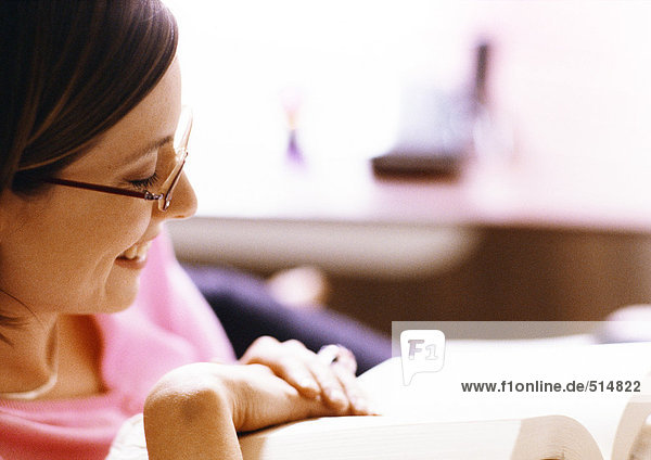 Woman reading book  smiling  close-up