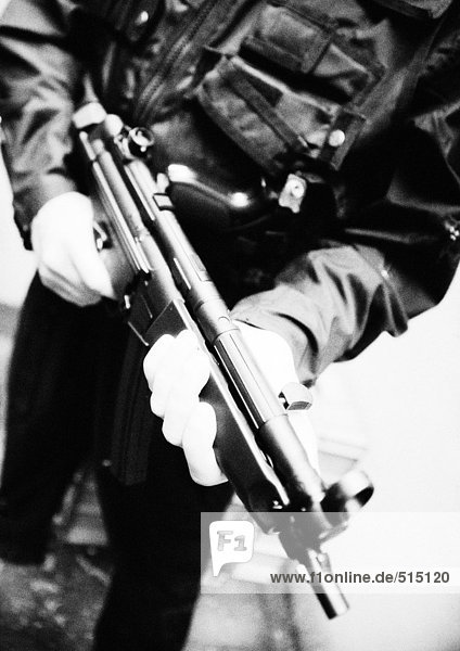 Man holding sub-machine gun  close-up  b&w