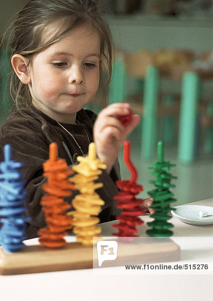Kinder spielen mit farbigen Kunststoffteilen