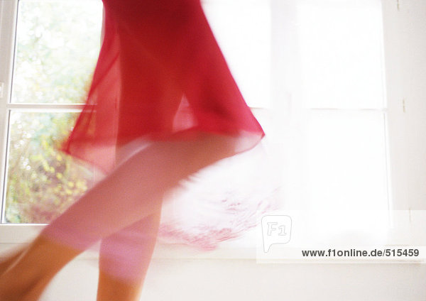 Frau walking vor Fenster, Unterteil, verschwommen Bewegung.