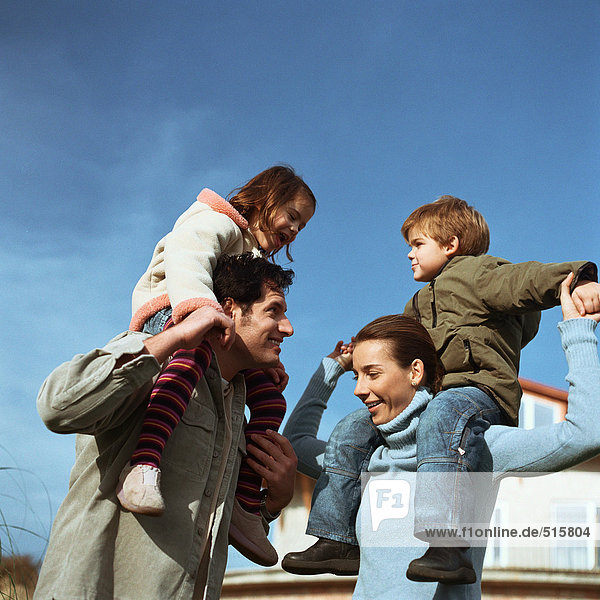 Children sitting on parents' shoulders