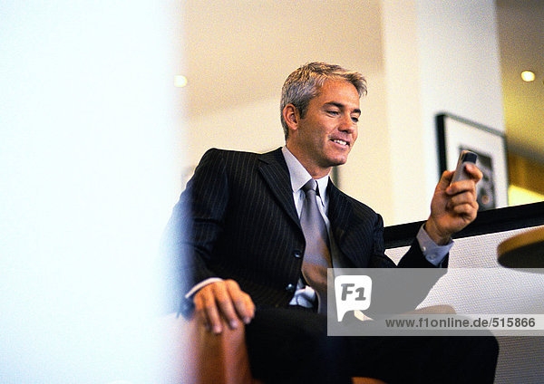 Businessman sitting holding cell phone