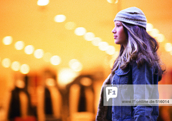 Girl walking by store window.