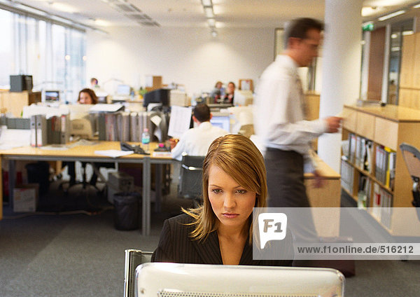 Geschäftsfrau  die am Computer arbeitet  Geschäftsleute  die im Hintergrund arbeiten.