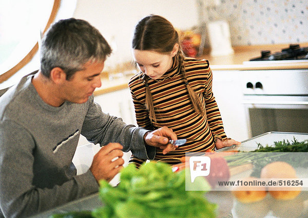 Father and daughter working together in kitchen