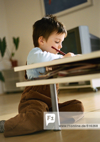 Kleiner Junge auf dem Boden hinter dem Couchtisch sitzend  Zeichnung  in Wohnzimmereinrichtung  kippbar
