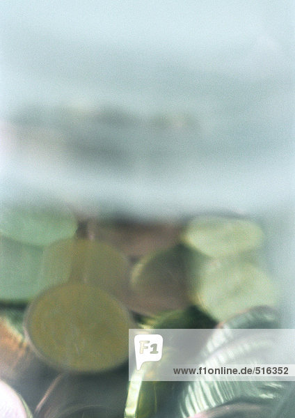 Verschiedene Münzen im Kunststoffbehälter gemischt  Nahaufnahme