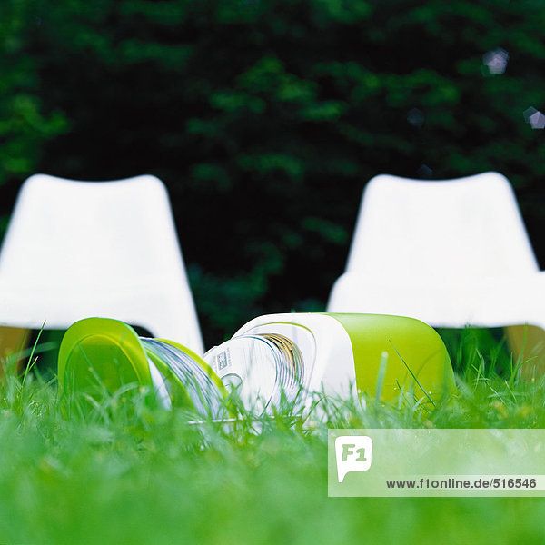 CD-Hülle  offen auf Gras  weiße Plastikstühle im Hintergrund