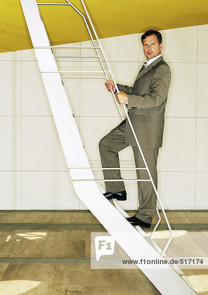 Man standing on ladder  looking into camera