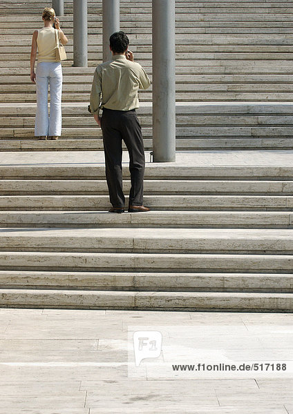 Man and woman standing on stairs outside  rear view