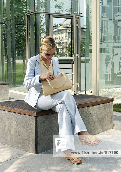 Woman sitting outside  holding purse