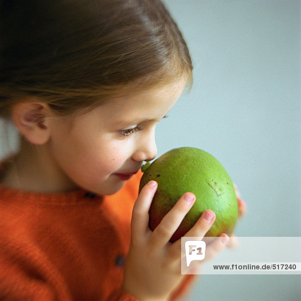 Girl smelling fruit  head and shoulders  close-up