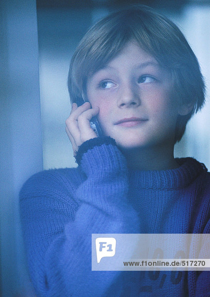 Junge spricht am Telefon  schaut aus dem Fenster  Portrait