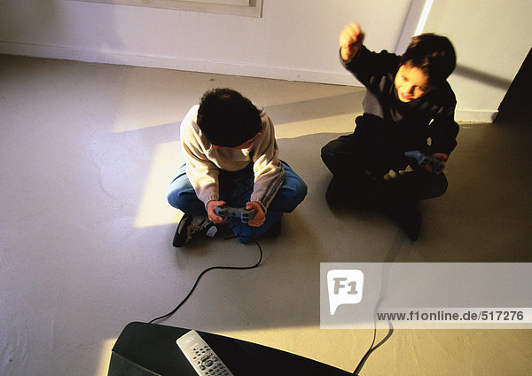 Junge Jungen sitzen auf dem Boden und spielen Videospiel  Blick in den hohen Winkel