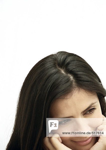 Woman tilting head  chin in hands  portrait
