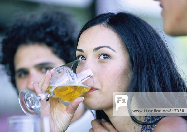 Frau trinkt aus Glas  neben dem Mann  Nahaufnahme